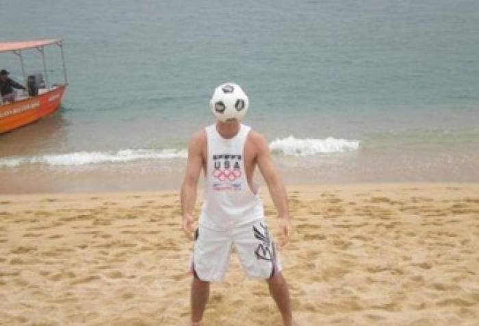 мужчина ловит мяч на пляже